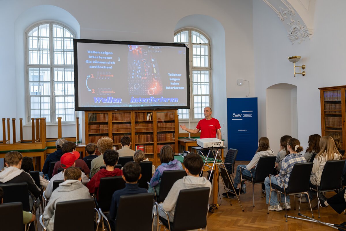A scientist holding a power point presentation in front of a school class