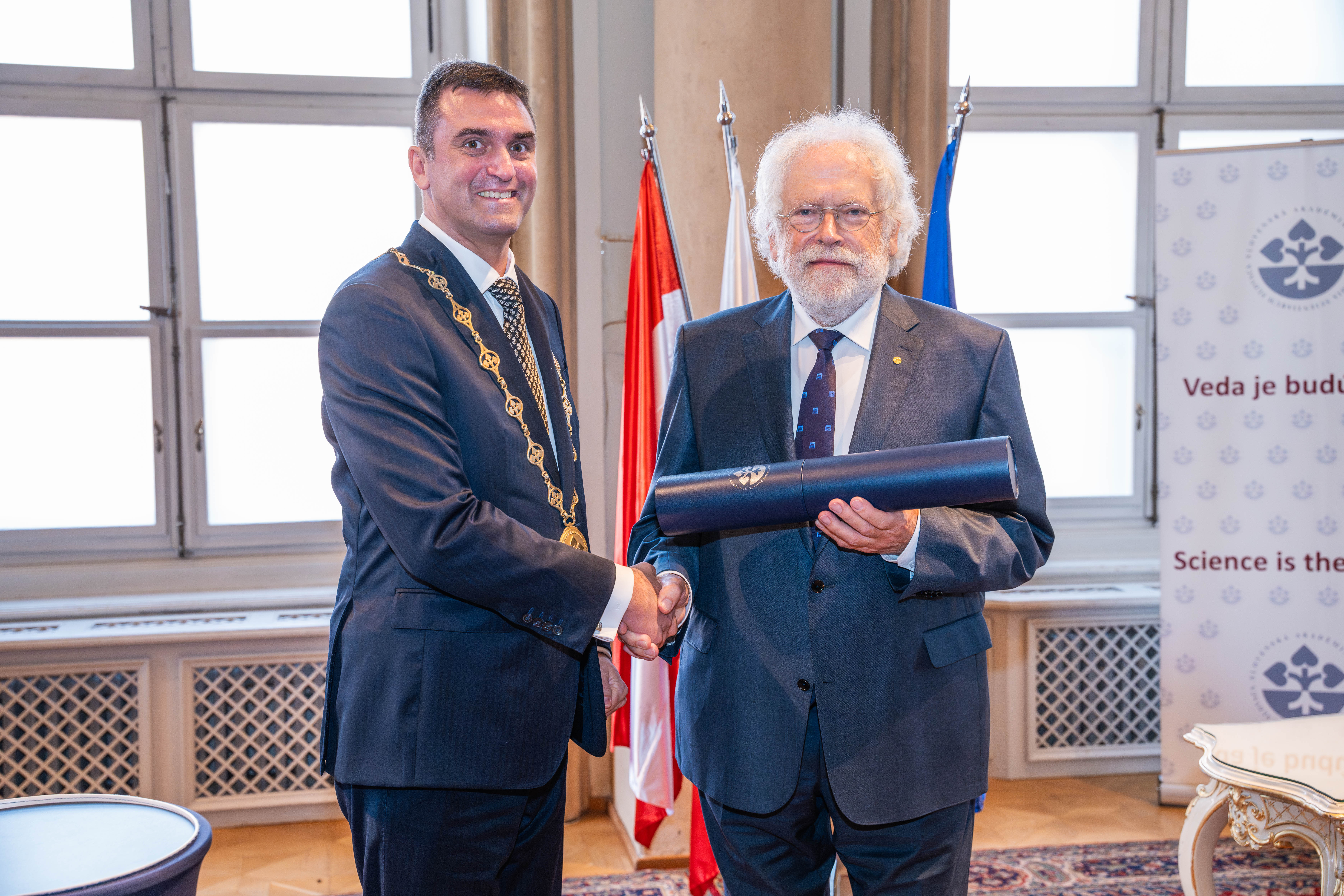 Anton Zeilinger and the President of the Slovak Academy of Sciences, Martin Venhart, posing for a picture with the honorary degree Prof. Zeilinger received