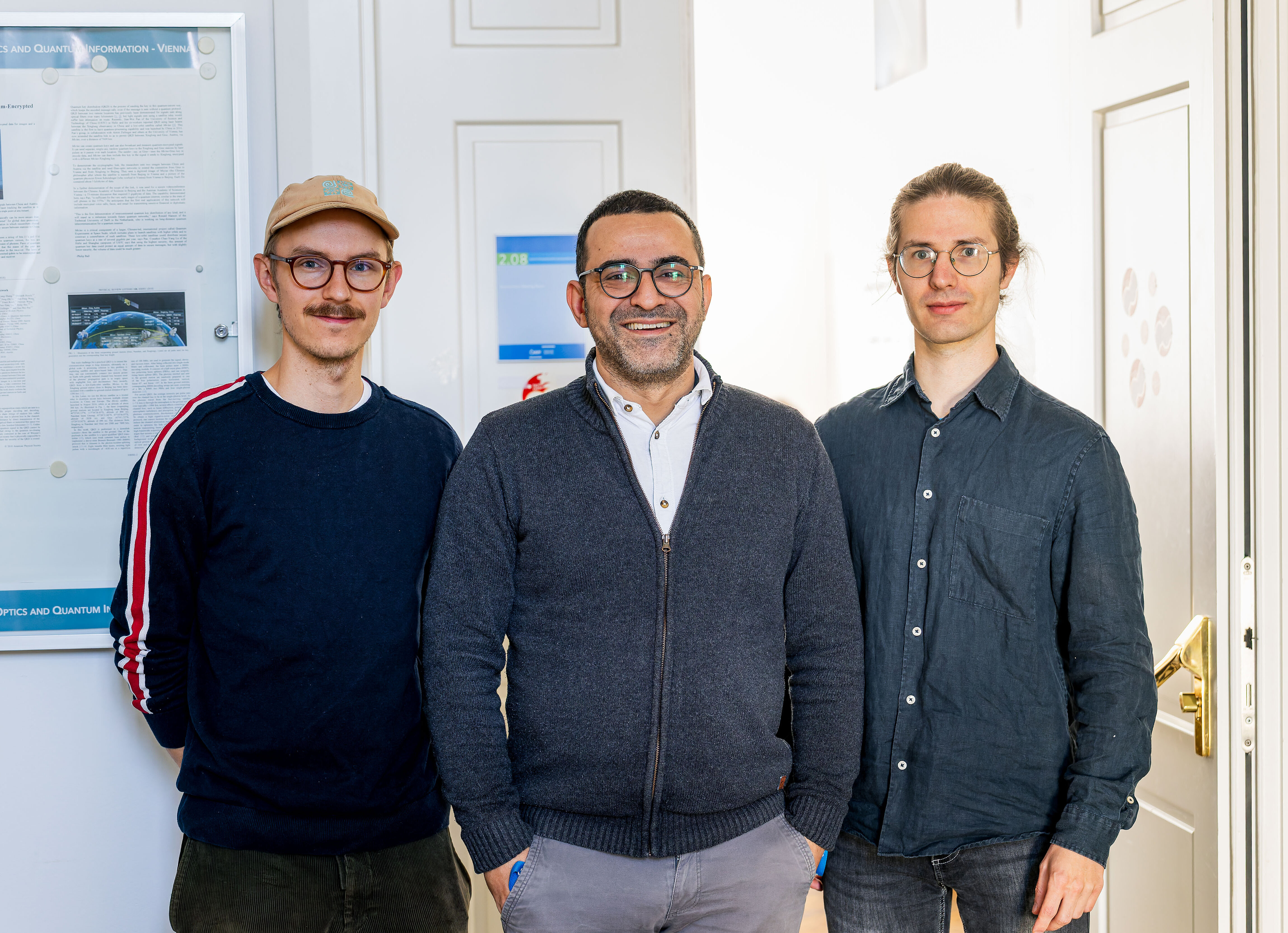 three scientists posing for a picture in front of the seminar room