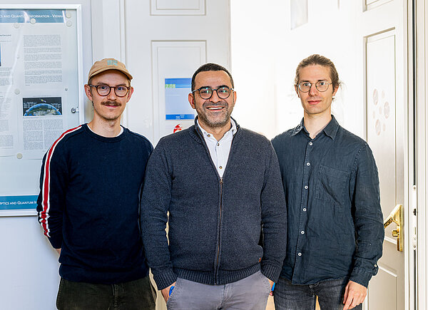 three scientists posing for a picture in front of the seminar room